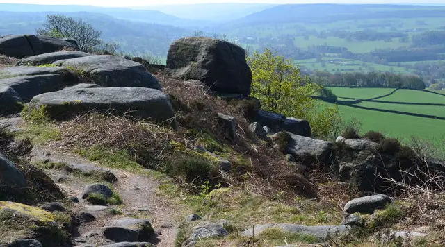 A path running along Baslow Edge with open Derbyshire countryside beyond